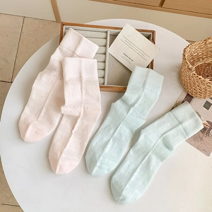 Detail of breathable hollow mesh cotton socks in pastel pink and light mint green