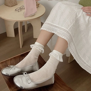 Silver ballet flats with bow and white lace socks in a vintage aesthetic setting
