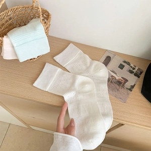 Detail of breathable hollow mesh cotton crew socks in white, blue and pink colors