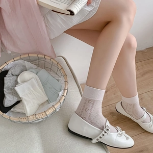 Detail of breathable mesh crew socks featuring hollow heart patterns in various colors