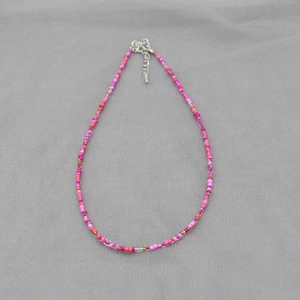 Colorful Bohemian beaded necklace with vibrant pink and orange beads and silver clasp