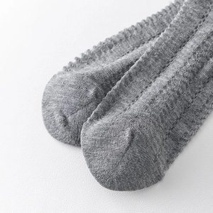 Close-up of grey knit socks showing breathable mesh texture and ribbed pattern detail