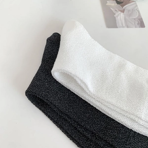 Close-up of black and white frilled knit socks with fine texture on white background