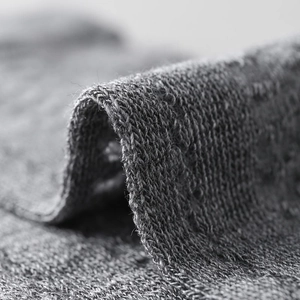 Close-up of dark grey knitted fabric showing detailed texture and soft breathable material