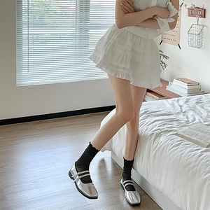 Silver Mary Jane flats with double straps and square toe paired with black ruffle socks