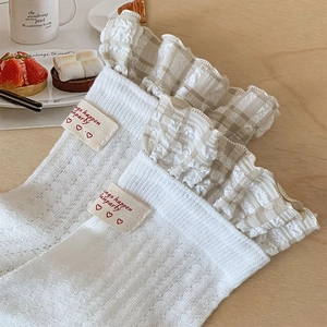 Detail of white ballet-style calf socks with plaid lace trim and cute fabric label