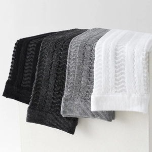 Detailed knit texture of mesh calf socks in black, dark grey, light grey, and white colors