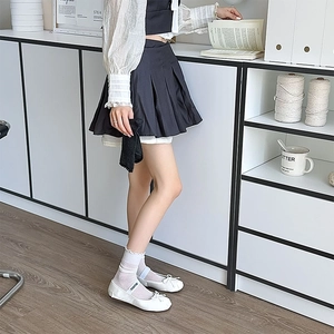 White ruffle lace socks paired with leather ballet flats and elastic branded logo straps