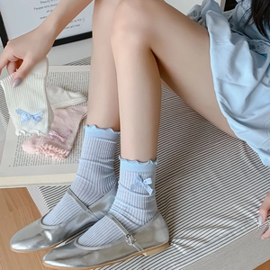 Close-up of three colors of ruffled crew socks with plaid bows for spring and summer