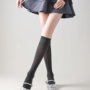 Detail von dunkelgrauen Overknee-Strümpfen mit Rippbündchen und feiner Strickstruktur