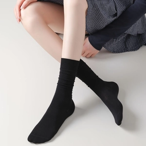 Detail von schwarzen Loos-Socks mit Rippbündchen kombiniert mit einem Karorock