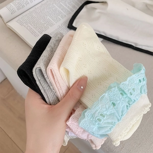 Dettaglio ravvicinato delle calze con bordo in pizzo e delicati ricami floreali colorati