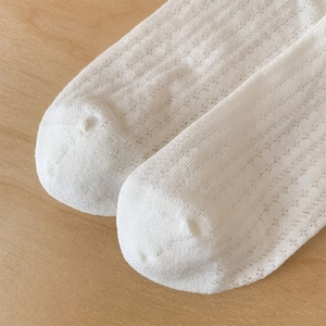 Detailed macro view of breathable mesh knit texture and reinforced toe of white socks