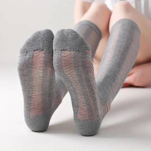 Detail of grey mesh knee-high socks featuring breathable vertical striped knit patterns
