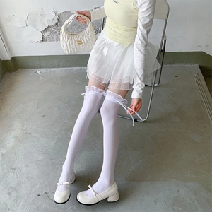 Close-up of white thigh-high socks featuring delicate lace edges and silk ribbon bows