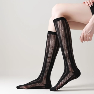 Detail showing sheer black knee-high socks with hollow vertical stripes and ribbed cuffs