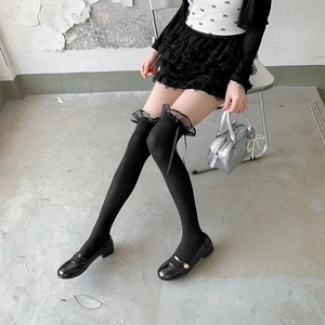 Japanese style black over-knee socks with lace trim and ribbons shown from a side view