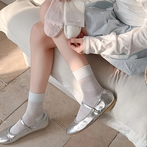 Close-up of white breathable pointelle mesh socks with ribbed cuffs and dot texture