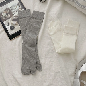 Close-up of split-toe tabi socks in grey and off-white with fine ribbed knit texture