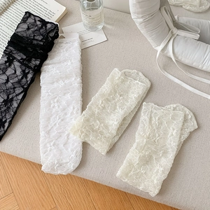 Detailed macro view of white floral lace stockings with elegant scalloped edge design