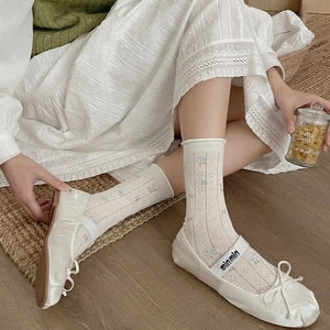 Close-up of ballet flat shoes with satin fabric, bow detail and grey lace socks