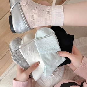 Breathable mesh crew socks in five colors with rib cuffs on a cozy wooden floor