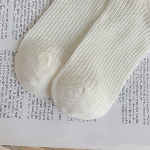 Macro detail of white ribbed cotton texture and seamless toe on sweet mid-calf socks