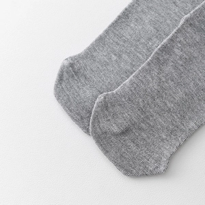 Nahaufnahme grauer Strickloden mit feiner Textur und Details der Zehennaht