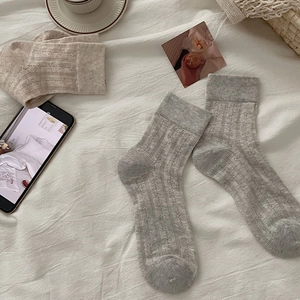 Detail of white ballet-style hollow knit socks with bow and floral jacquard pattern