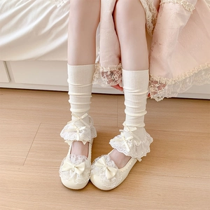 Close-up of Lolita style Mary Jane shoes and socks with delicate lace and bows