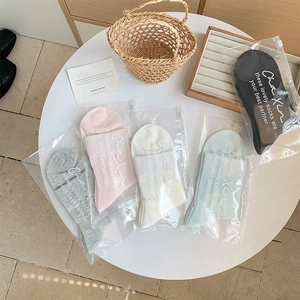 Set of five heart hollow-out crew socks in pastel colors with individual zipper bags