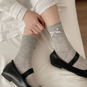 Grey ballet core socks with lavender bows and vertical ribbed texture worn by a model