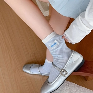 Close-up of light blue ribbed crew socks with contrast cuff and cloud embroidery