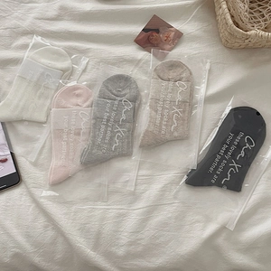 Detailed view of ballet-style mesh socks in 5 colors with bow and zip bag packaging