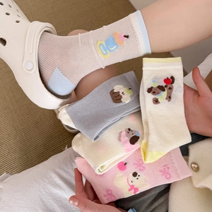 Close-up of breathable mesh texture and cute cartoon animal embroidery on pink crew socks
