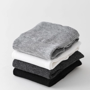Details von gestapelten Stricksocken in Grau Weiß und Schwarz mit weicher Rippstruktur