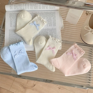 Detailed set of four ribbed socks with ruffled edges and small plaid bow decorations