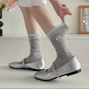 Detail of grey socks with cute dog embroidery and silver Mary Jane flat shoes