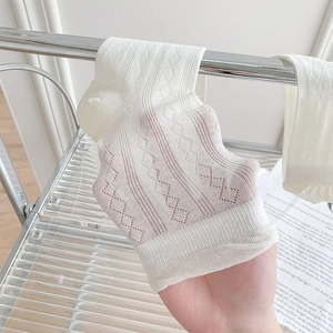 Close-up of white breathable mesh socks with diamond hollow texture and thin fabric