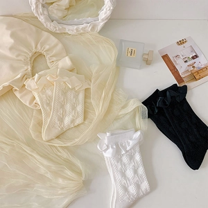 Gros plan de chaussettes Lolita en dentelle avec motifs en relief et bords à volants