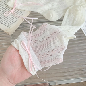 Dettaglio di calze in maglia traforata bianca con fiocchi rosa e stile vintage chic