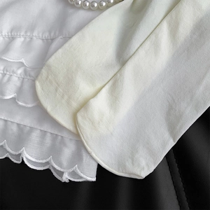 Detail of white thigh-high socks featuring delicate lace edges and a soft cotton texture