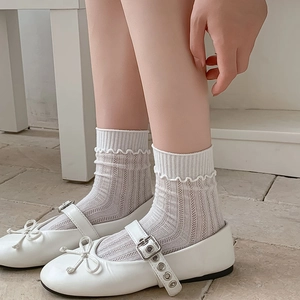Detail of white lace hollow mesh socks paired with Mary Jane shoes and ankle straps