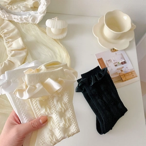 Détail de chaussettes mi-mollet style Lolita avec volants en dentelle et rayures verticales