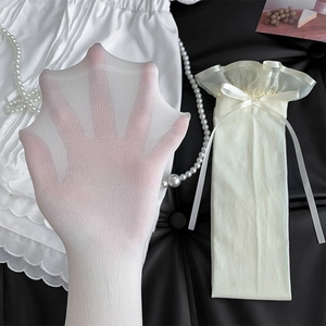 Close-up of white sheer thigh high stockings with satin bow and delicate lace ruffles