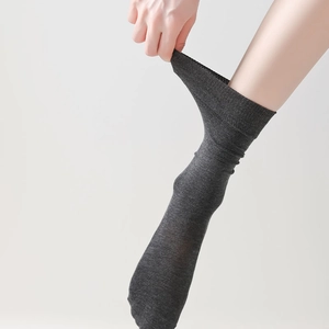 Nahaufnahme der hohen Elastizität und Dehnung dunkelgrauer kniehoher Baumwollmischsocken