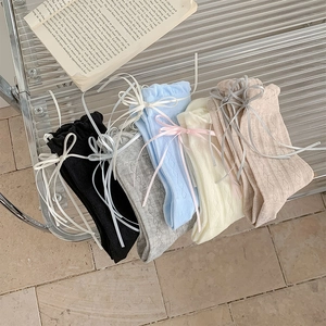 Dettaglio di confezione da cinque calze stile balletto con fiocchi e maglia a rombi