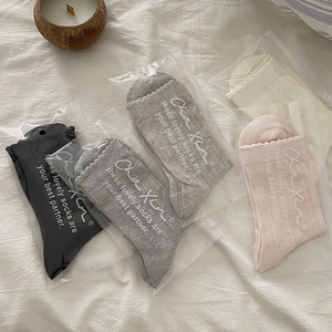Detail of four pairs of breathable mesh socks with ruffled cuffs in retail packaging