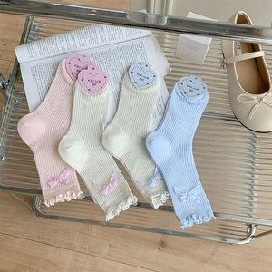 Detail of sweet ruffle cuff socks with plaid bows in pastel pink, green, white and blue
