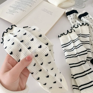 Detail of sweet heart pattern socks with mesh texture and ruffled lace cuffs for women